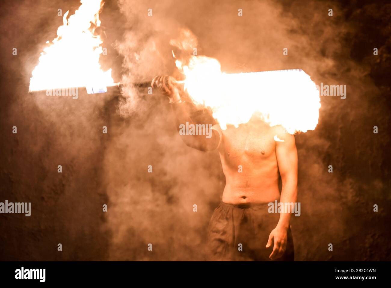 Fakir jongle feu sur un fond noir. Banque D'Images