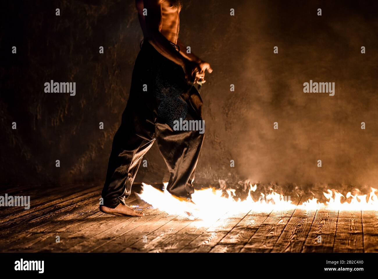 Fakir jongle feu sur un fond noir. Banque D'Images