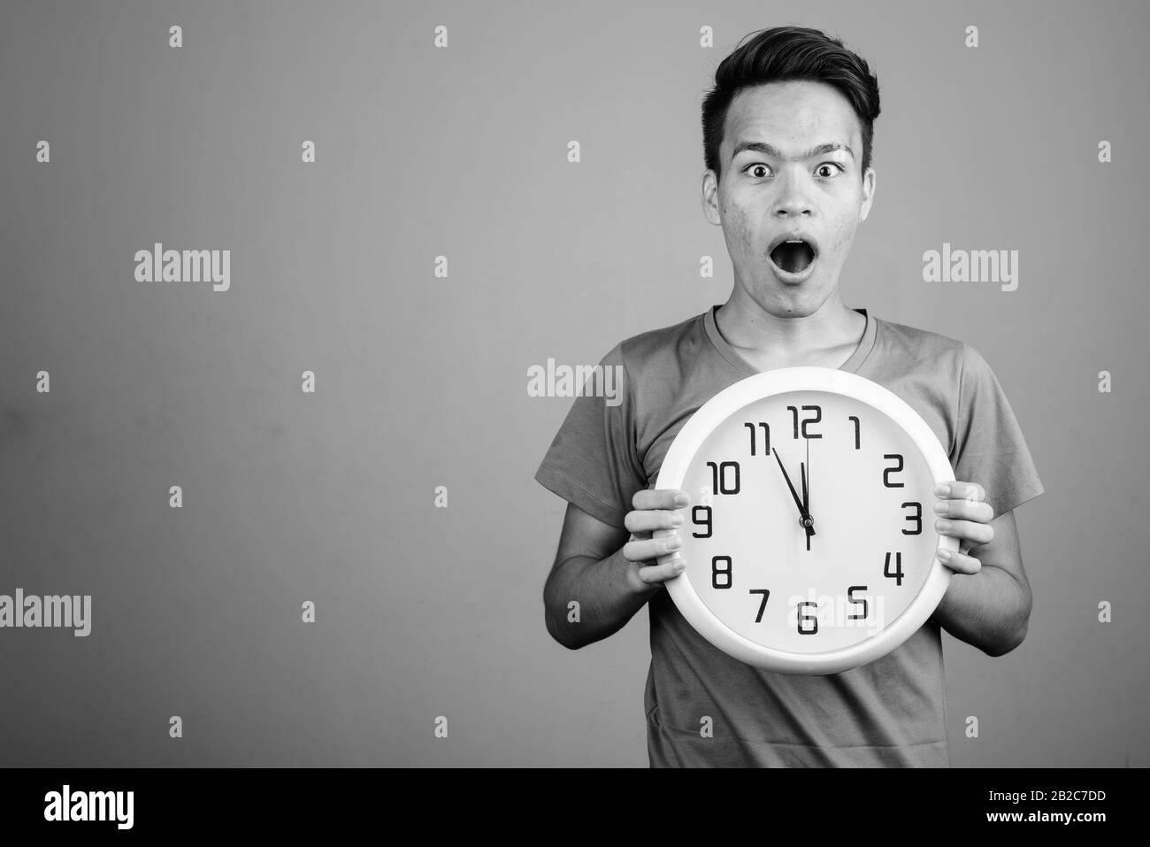 Beau jeune homme indien contre l'arrière-plan gris Banque D'Images