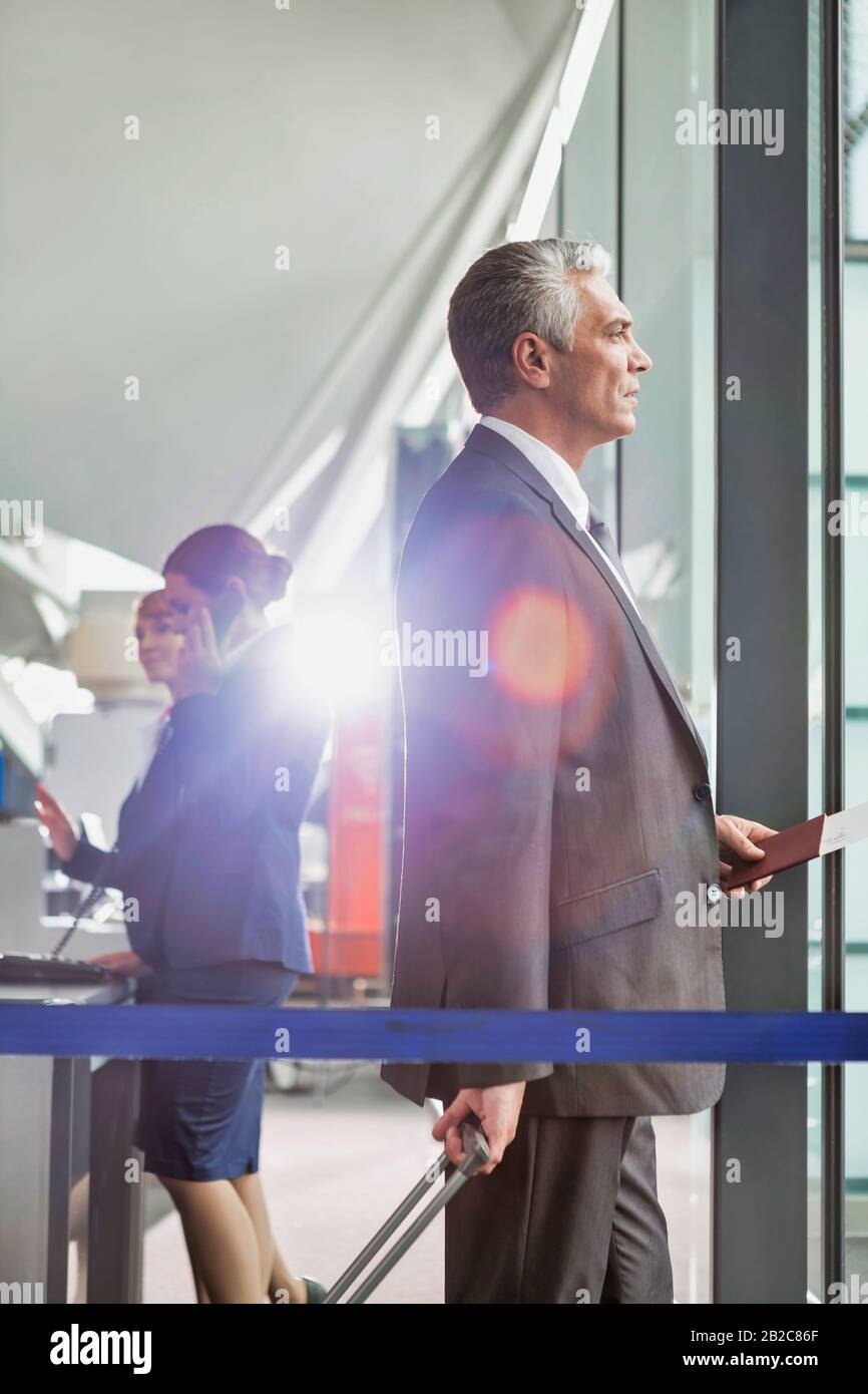 Portrait d'un homme d'affaires mûr à bord de l'avion à l'aéroport Banque D'Images
