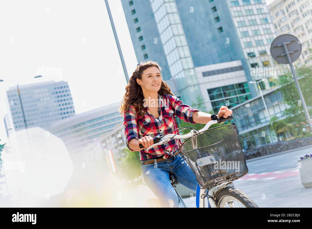 Portrait de la jeune belle femme souriant tout en faisant du vélo au milieu de la ville Banque D'Images