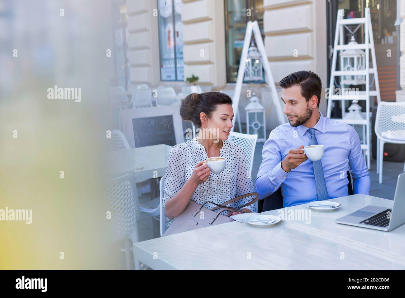 Femme d'affaires discutant de plans avec un homme d'affaires tout en prenant un café pendant la pause de bureau Banque D'Images Femme d'affaires discutant de plans avec un homme d'affaires tout en prenant un café pendant la pause de bureau Banque D'Images