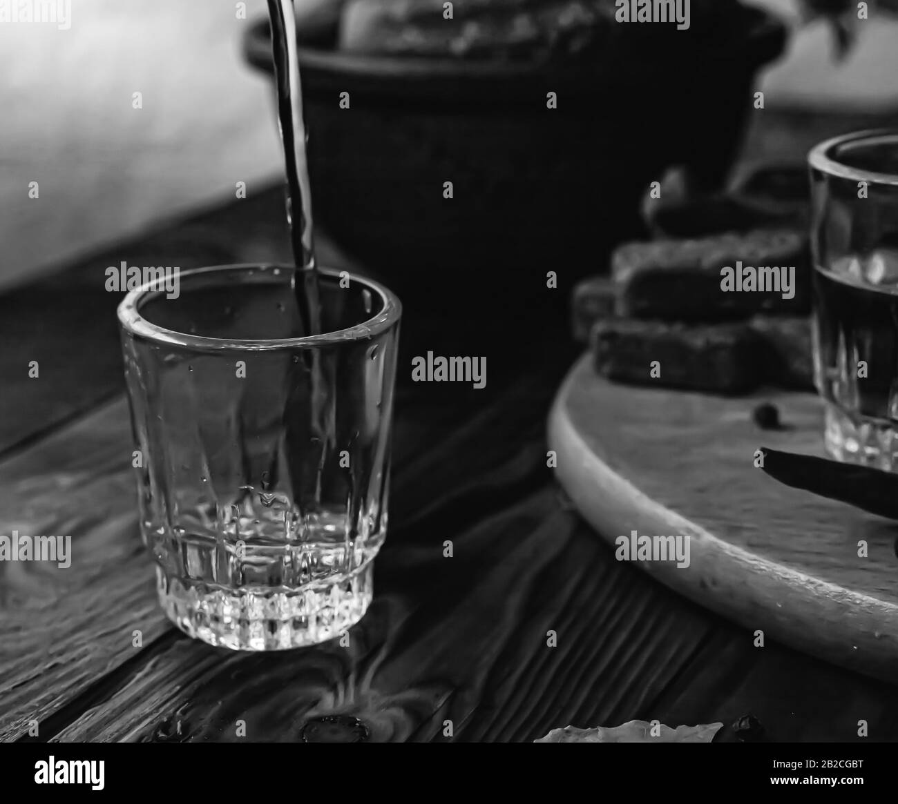 Vodka boisson traditionnelle dans des verres, avec une collation sous forme de charcuterie et bacon, concombres, conservation. Table nationale de fête russe. Banque D'Images