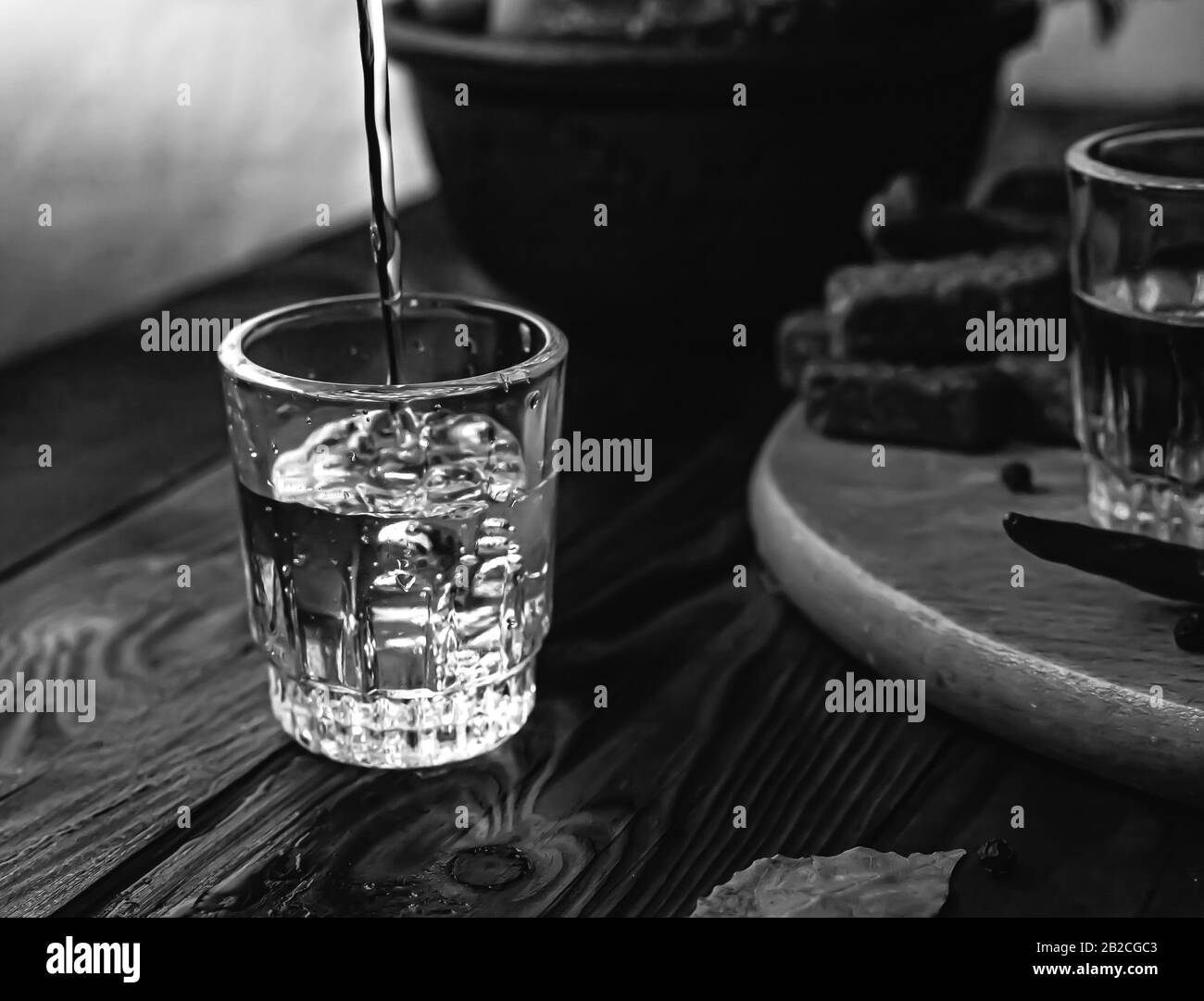 Vodka boisson traditionnelle dans des verres, avec une collation sous forme de charcuterie et bacon, concombres, conservation. Table nationale de fête russe. Banque D'Images