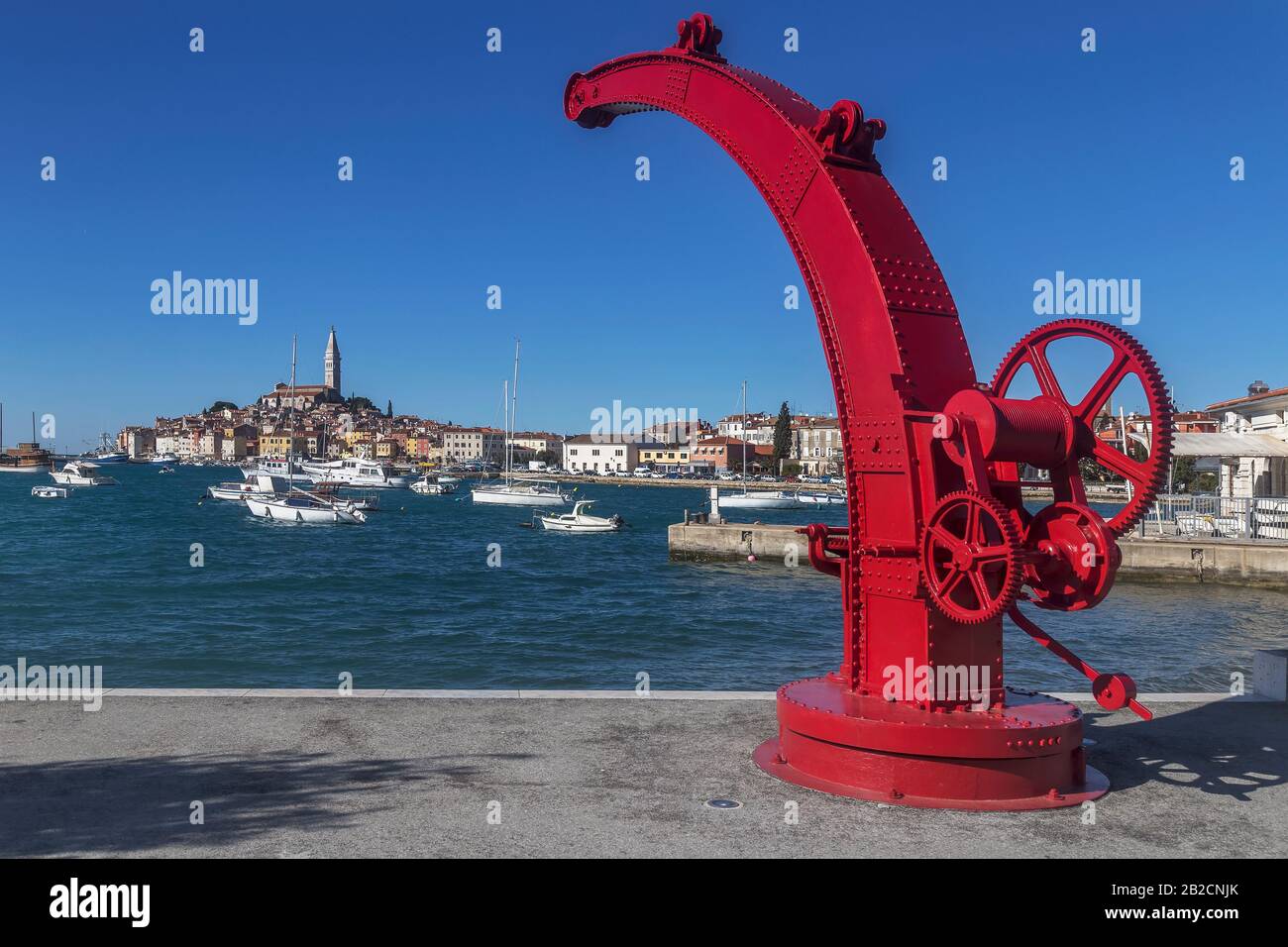 Ancienne grue peinte en rouge, en arrière-plan vieille ville de Rovinj - Rovigno, Istrie, Croatie Banque D'Images