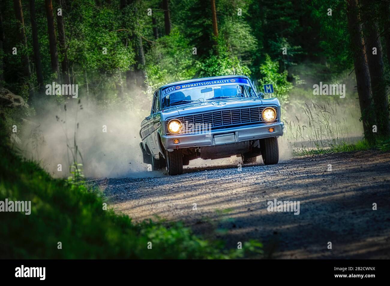Ford Falcon sur une route poussiéreuse de gravier dans le rallye suédois au soleil de minuit Banque D'Images