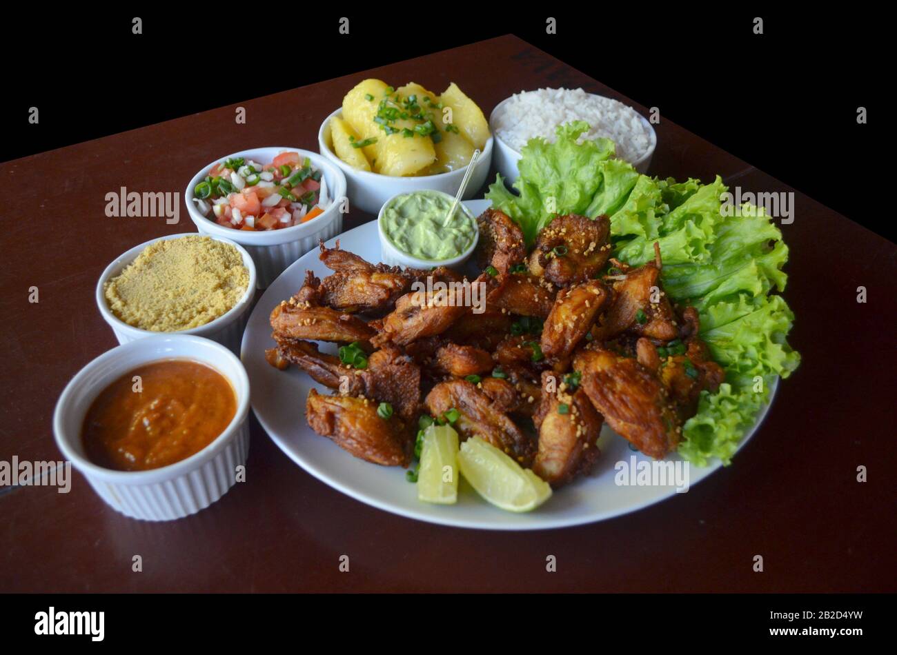 Aile de poulet frit avec ail et citron. Plat de restaurant brésilien. Banque D'Images