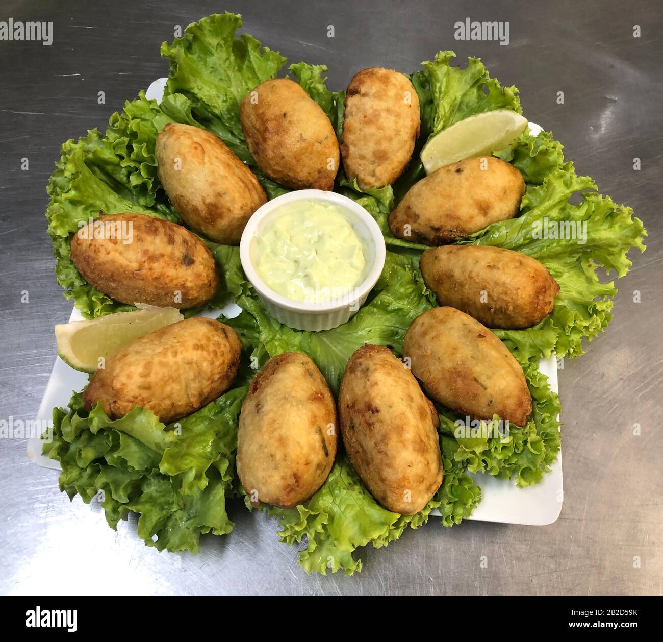 Aile de poulet frit avec ail et citron. Plat de restaurant brésilien. Banque D'Images