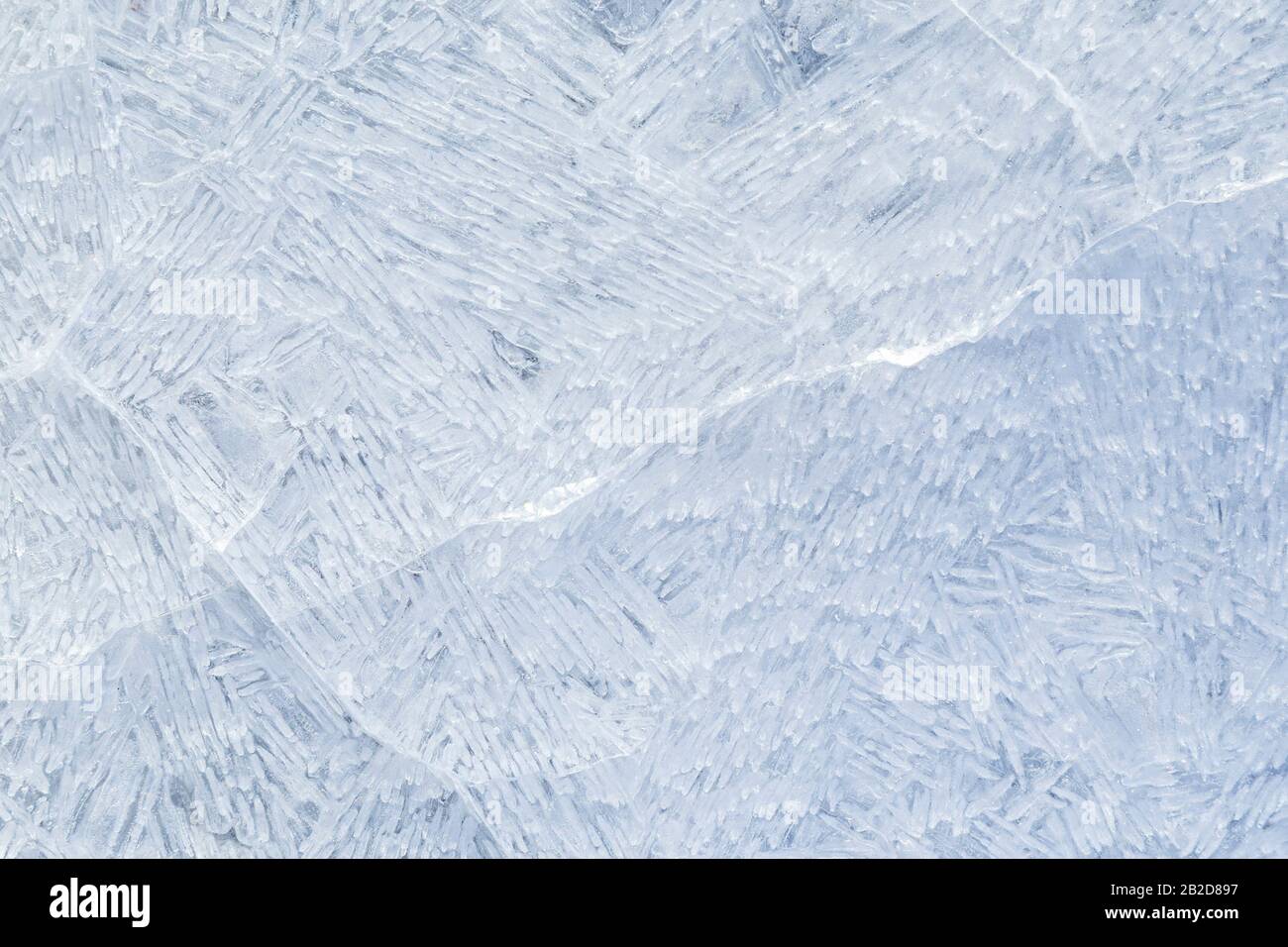 Gros plan de glace craquelée sur un lac gelé en hiver, vue du dessus. Arrière-plan plein cadre abstrait. Espace de copie, vue de dessus. Banque D'Images