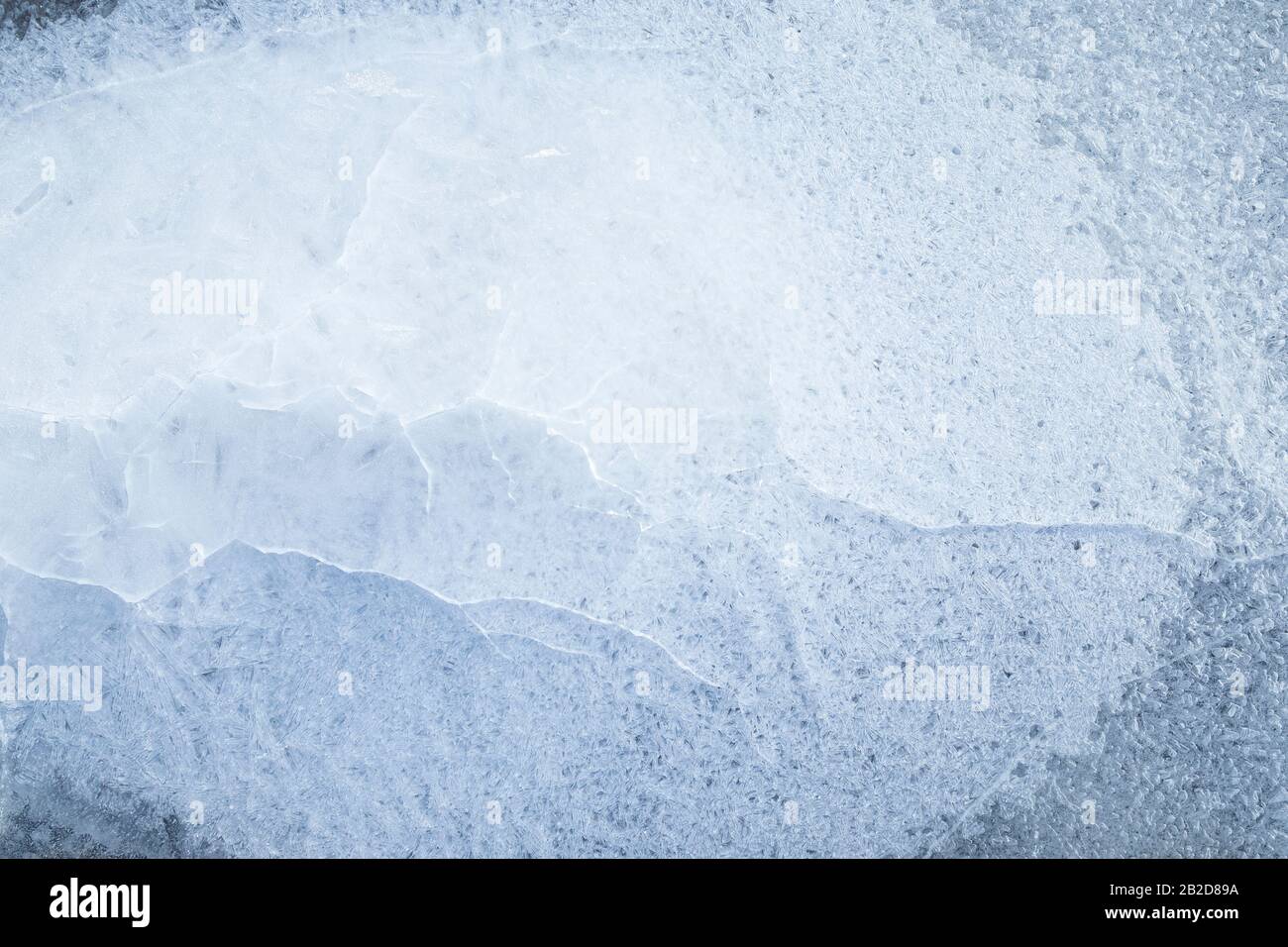 Gros plan de glace craquelée sur un lac gelé en hiver, vue du dessus. Arrière-plan plein cadre abstrait. Espace de copie, vue de dessus. Banque D'Images