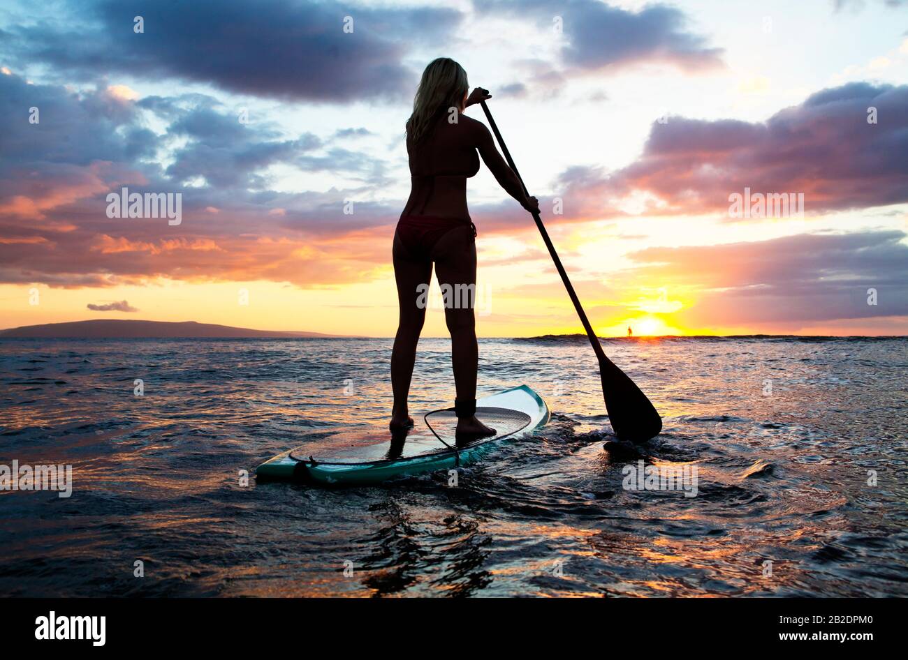 Une femme active paddle un paddle debout au coucher du soleil à Cove Park,  Kihei, Maui, Hawaï Photo Stock - Alamy