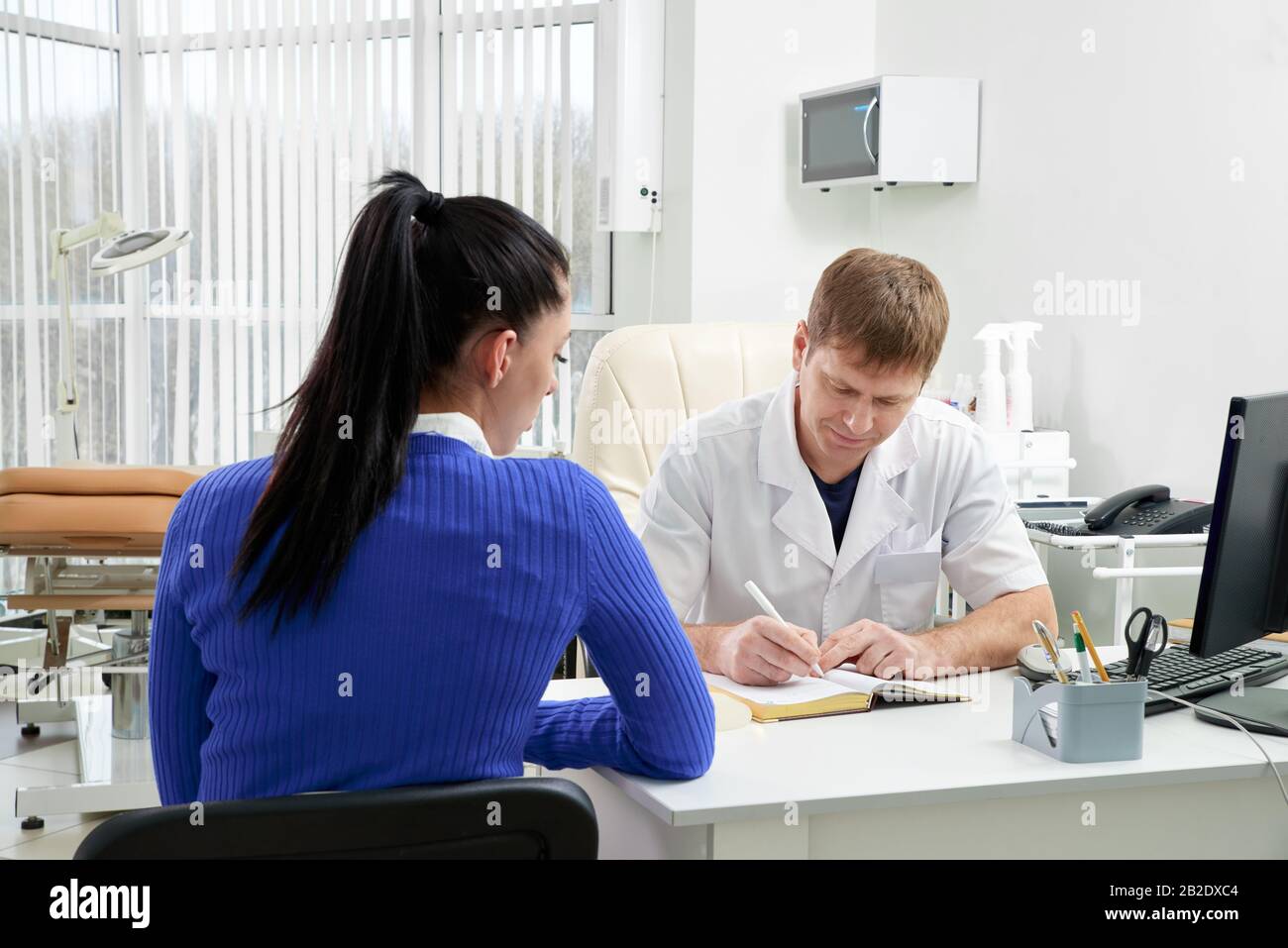Médecin consultant la jeune femme dans son bureau Banque D'Images