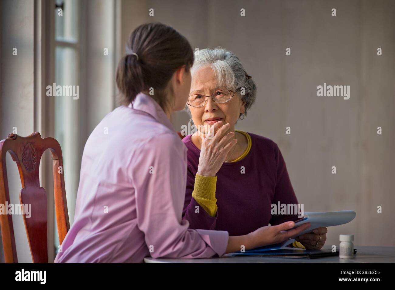 Femme âgée qui parle avec son soignant Banque D'Images