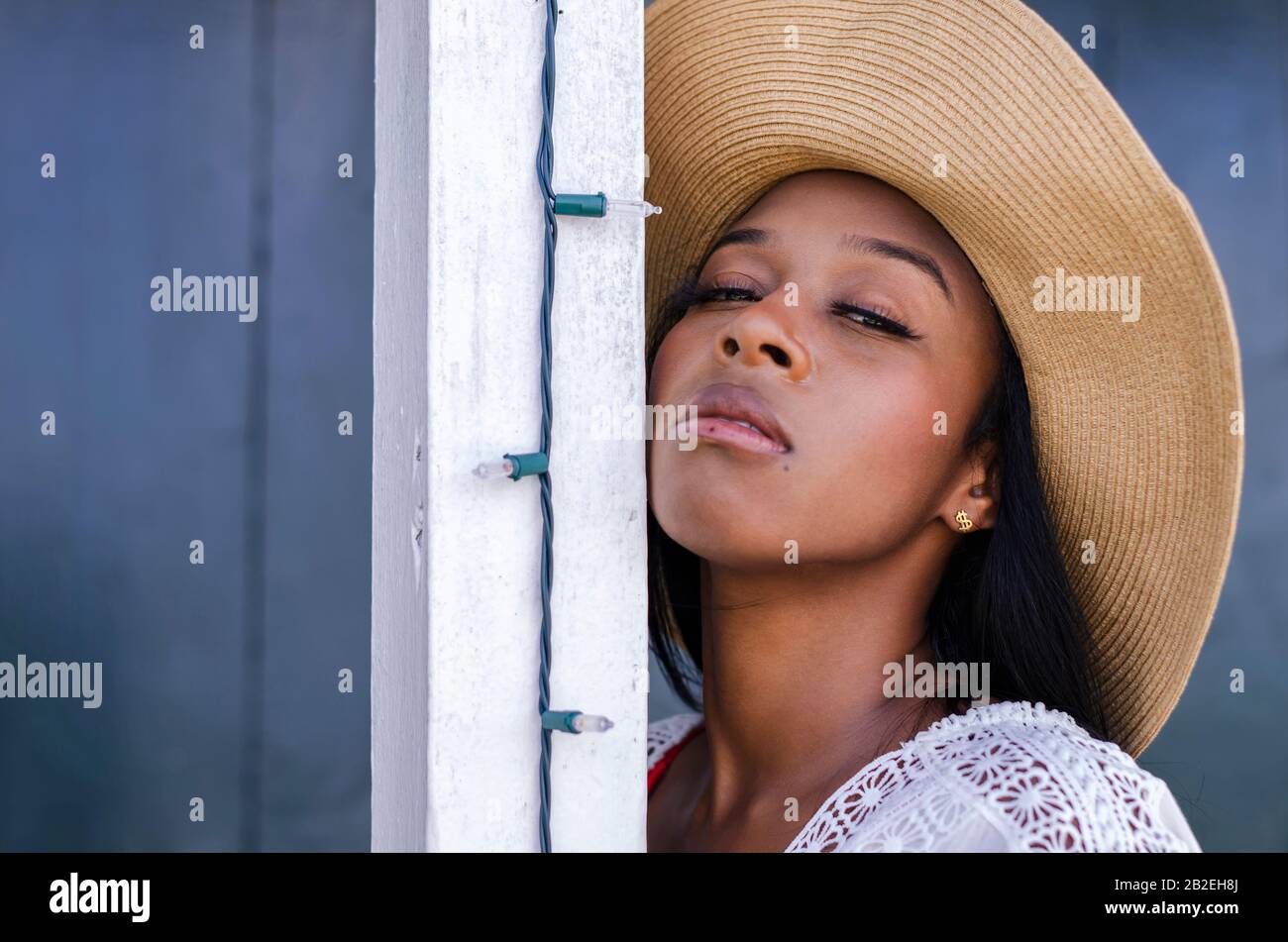 Femme noire de 25 à 30 ans, devant une porte d'église, vêtue de modèles blancs, de vêtements frais d'été et tropicaux Banque D'Images