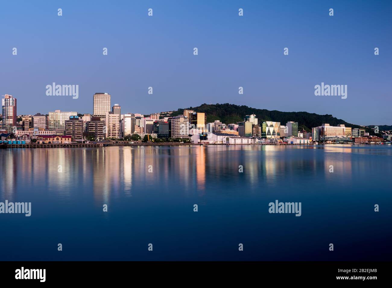 Wellington, les bâtiments de la ville de Nouvelle-Zélande et les gratte-ciel se reflètent dans le port au lever du soleil lors d'une matinée d'été parfaite. Wellington est la capitale de la Nouvelle-Zélande. Banque D'Images