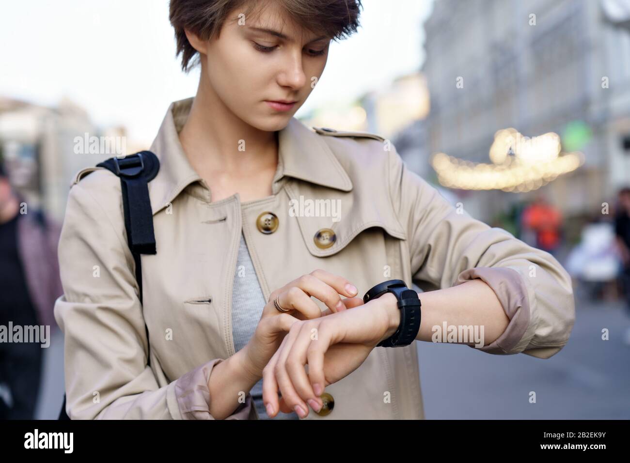 Jeune fille en utilisant la montre intelligente marchant sur la rue de la ville. Banque D'Images