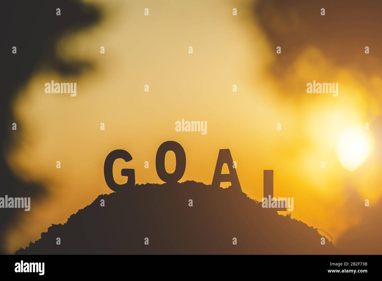 Silhouette du mot « BUT » en haut de la colline au coucher du soleil. Pour le concept de cible métier Banque D'Images