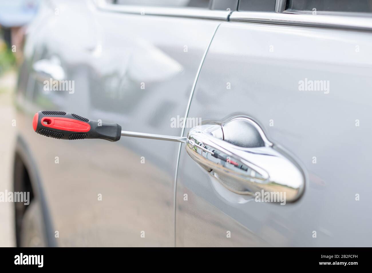 Un technicien automobile porte des gants blancs et utilise un tournevis  pour fixer, réparer ou ouvrir la porte d'une voiture moderne Photo Stock -  Alamy
