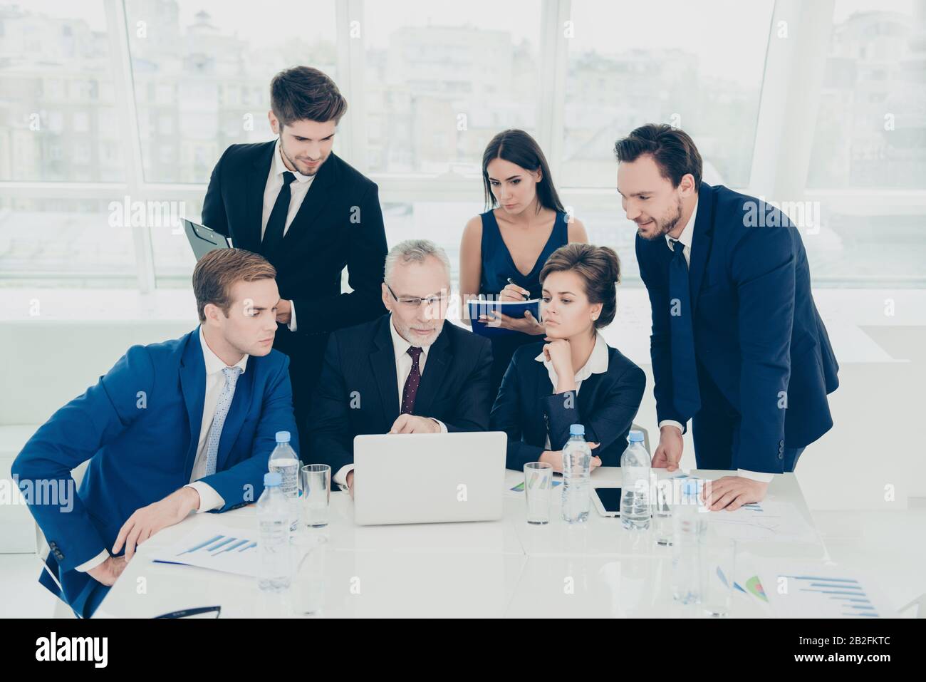 Équipe chargée d'hommes d'affaires travaillant à mettre fin au projet financier à temps Banque D'Images