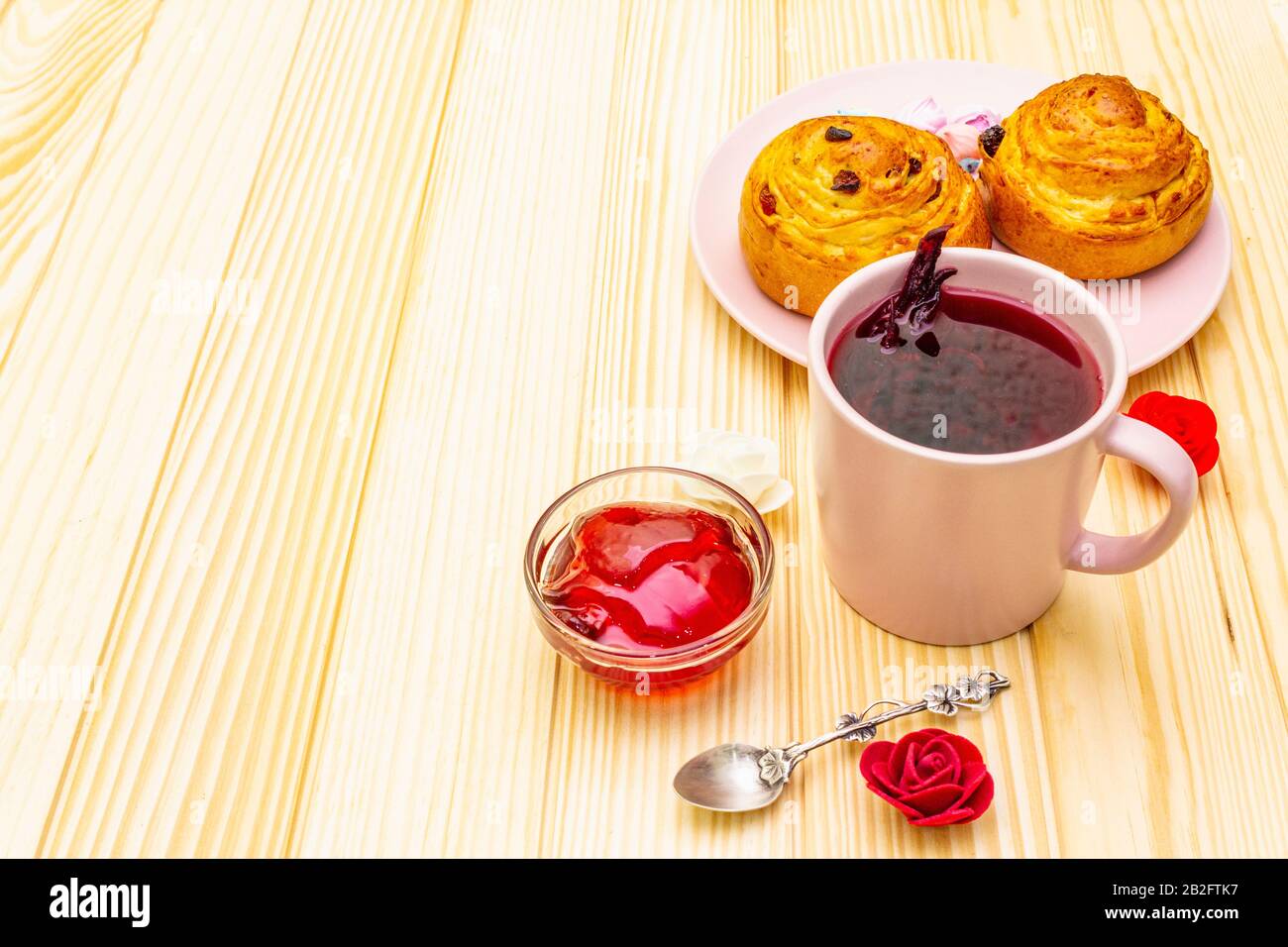 Thé Karkade à partir de pétales d'hibiscus (rose soudanaise). Petit déjeuner romantique et doux. Petits pains, meringues, gelée de fraises. Sur un fond en bois, copier s Banque D'Images