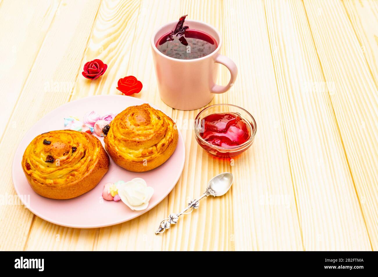Thé Karkade à partir de pétales d'hibiscus (rose soudanaise). Petit déjeuner romantique et doux. Petits pains, meringues, gelée de fraises. Sur un fond en bois, copier s Banque D'Images