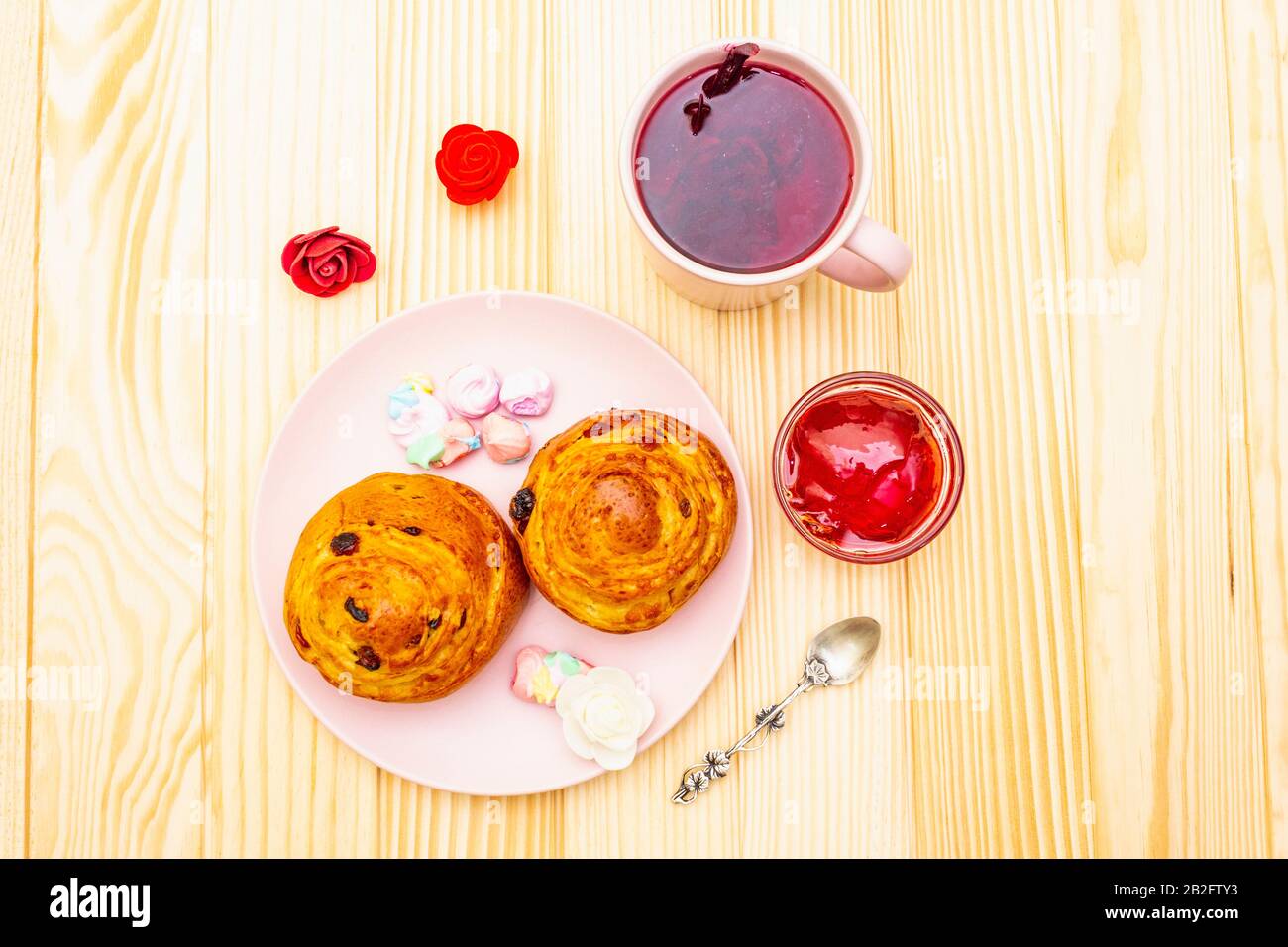 Thé Karkade à partir de pétales d'hibiscus (rose soudanaise). Petit déjeuner romantique et doux. Petits pains, meringues, gelée de fraises. Sur un fond en bois, haut vi Banque D'Images