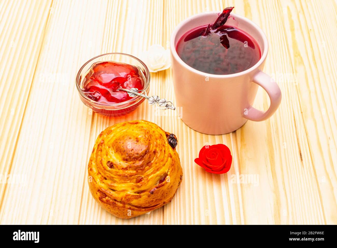 Thé Karkade à partir de pétales d'hibiscus (rose soudanaise). Petit déjeuner romantique et doux. Petits pains, meringues, gelée de fraises. Sur un fond en bois Banque D'Images