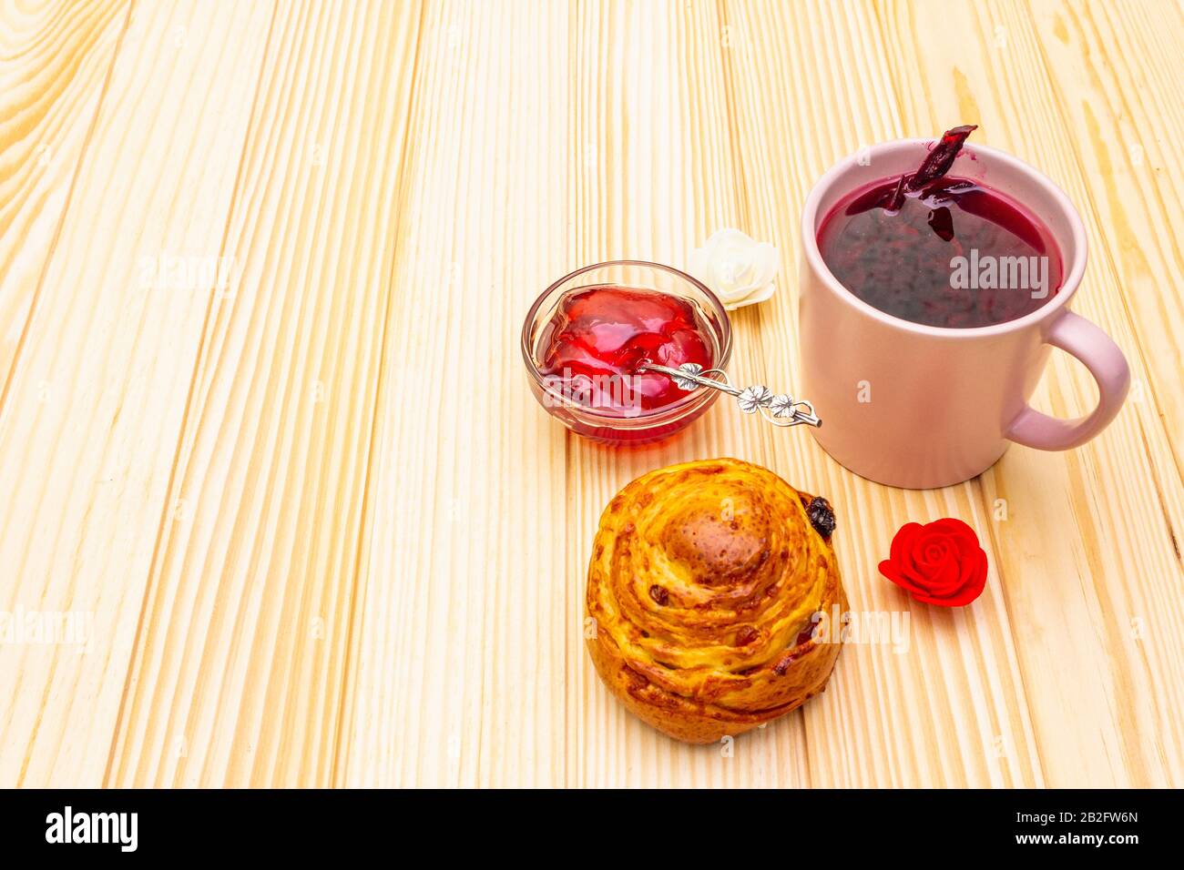 Thé Karkade à partir de pétales d'hibiscus (rose soudanaise). Petit déjeuner romantique et doux. Petits pains, meringues, gelée de fraises. Sur un fond en bois, copier s Banque D'Images