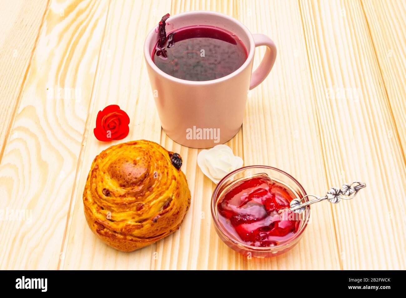 Thé Karkade à partir de pétales d'hibiscus (rose soudanaise). Petit déjeuner romantique et doux. Petits pains, meringues, gelée de fraises. Sur un fond en bois Banque D'Images