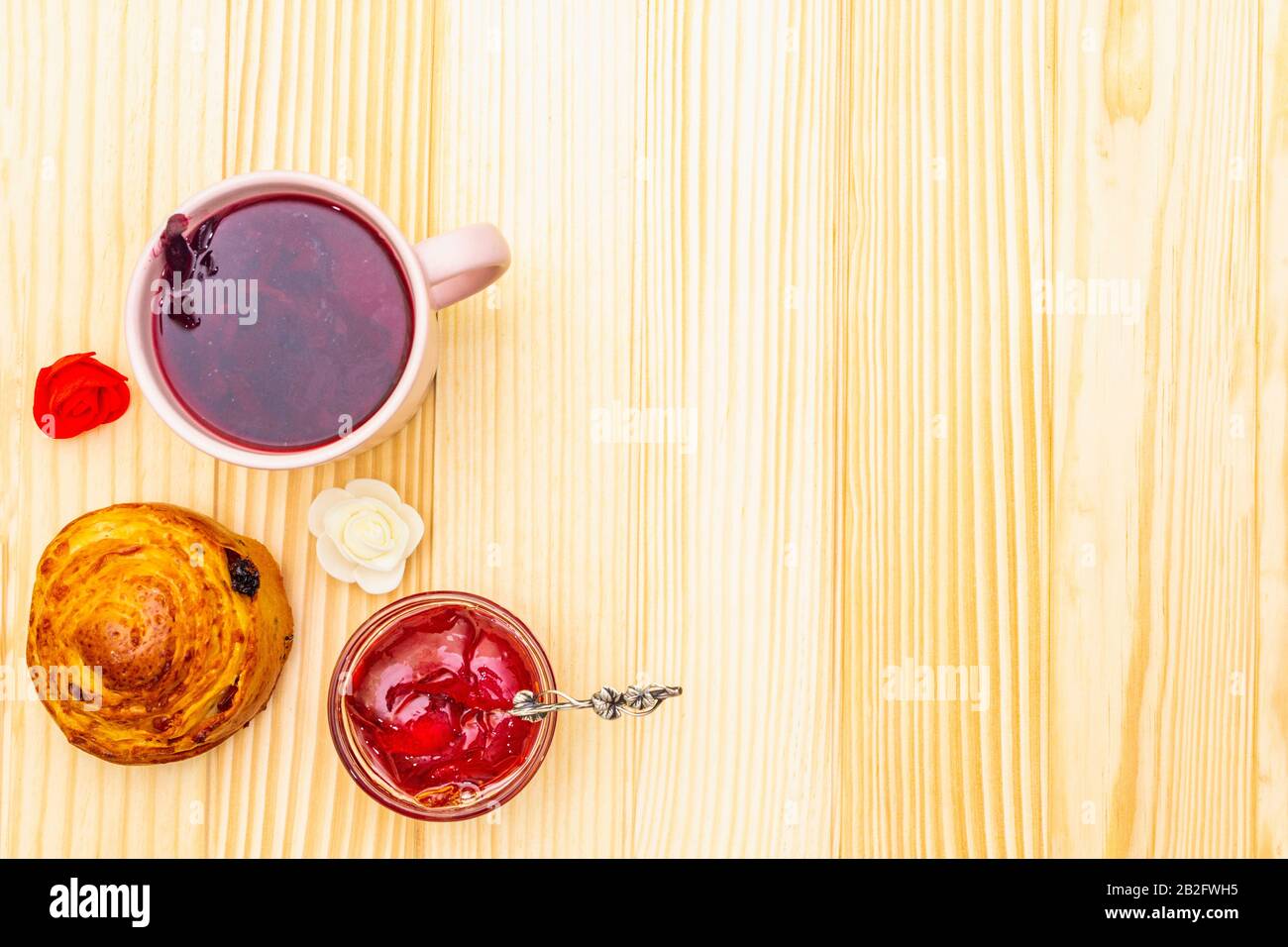 Thé Karkade à partir de pétales d'hibiscus (rose soudanaise). Petit déjeuner romantique et doux. Petits pains, meringues, gelée de fraises. Sur un fond en bois, haut vi Banque D'Images
