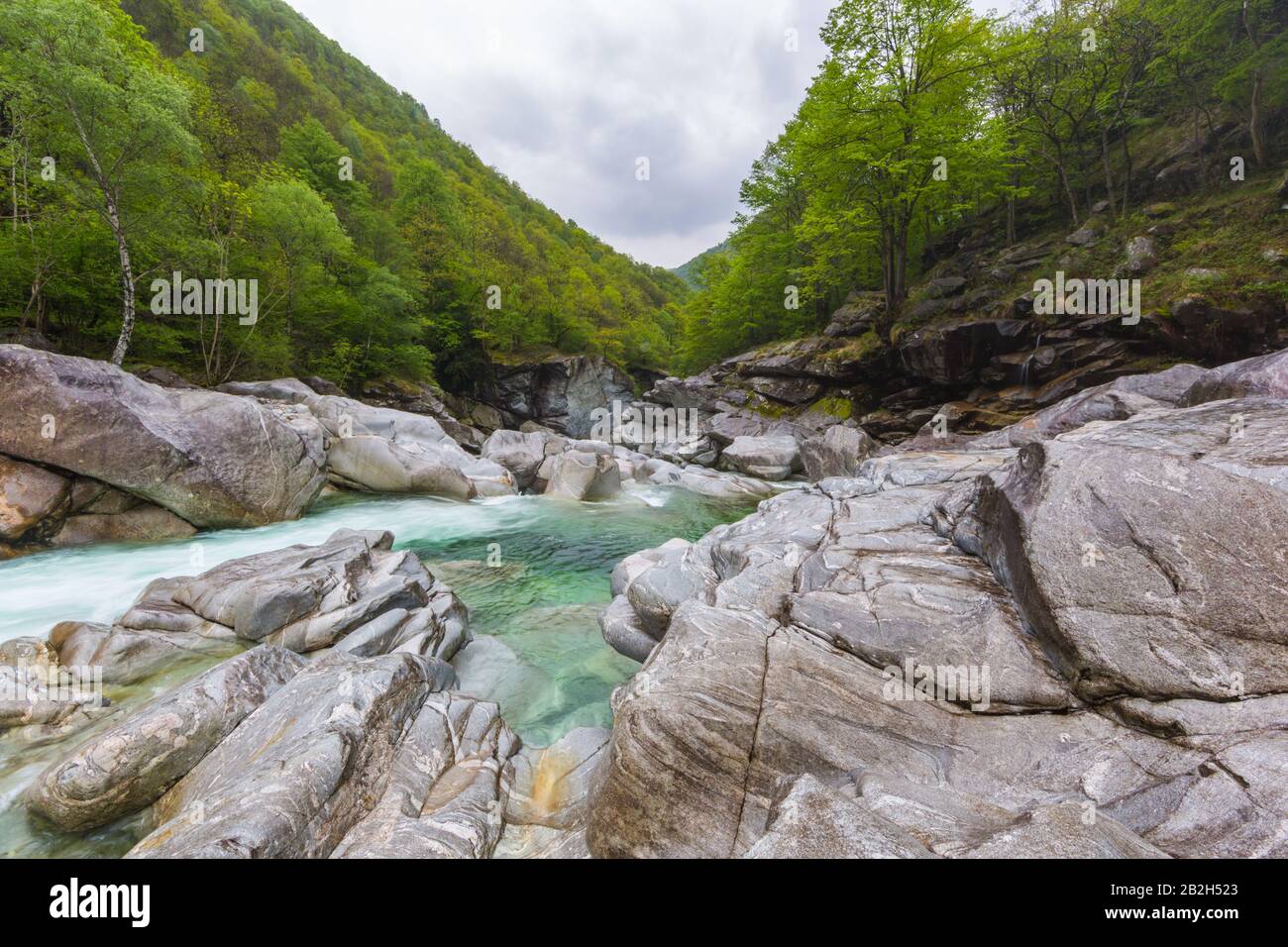 Formations rocheuses naturelles et rivière Verzasca avec forêt verte et nuages Banque D'Images