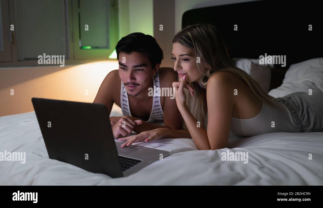 Jeune couple regardant l'ordinateur portable ensemble Banque D'Images