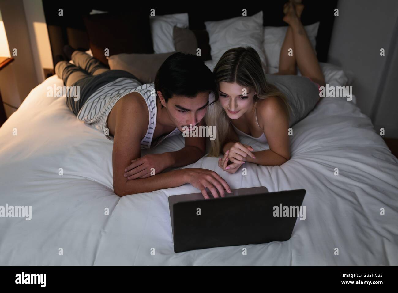 Jeune couple regardant l'ordinateur portable ensemble Banque D'Images