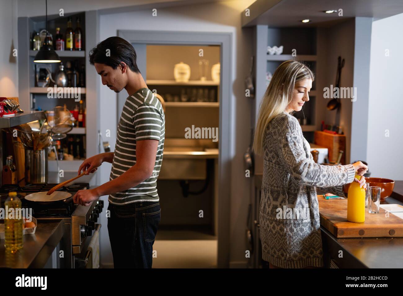 Jeune couple cooking together at home Banque D'Images
