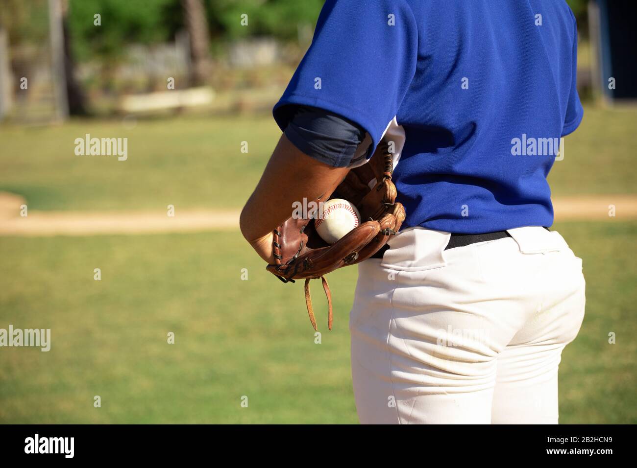 Joueur de base-ball tenant la balle avec des gants de base-ball Banque D'Images