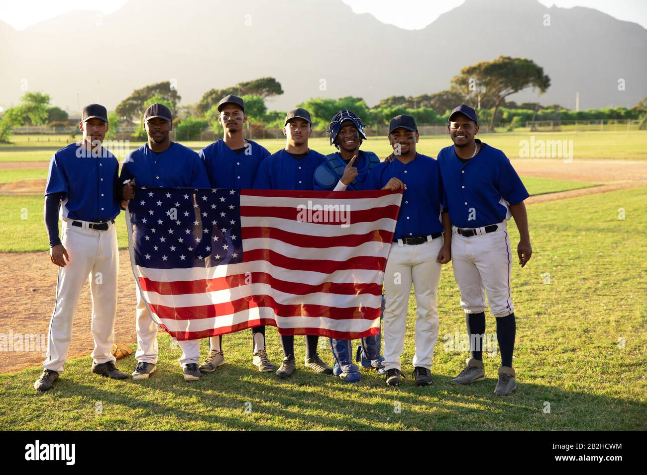 Joueurs de base-ball en ligne avec un drapeau américain Banque D'Images