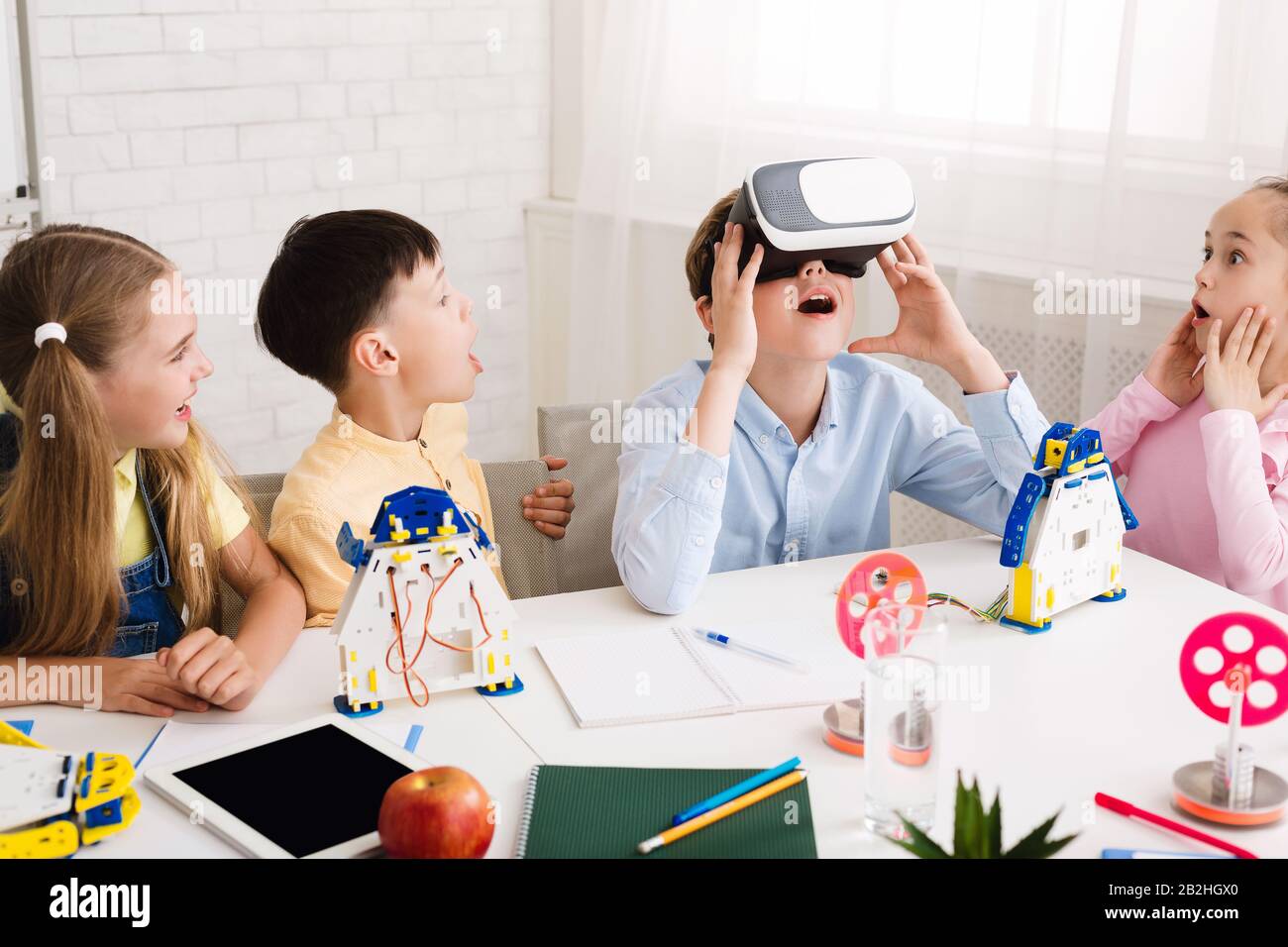 Garçon scolaire utilisant des lunettes VR à la leçon de tige Banque D'Images