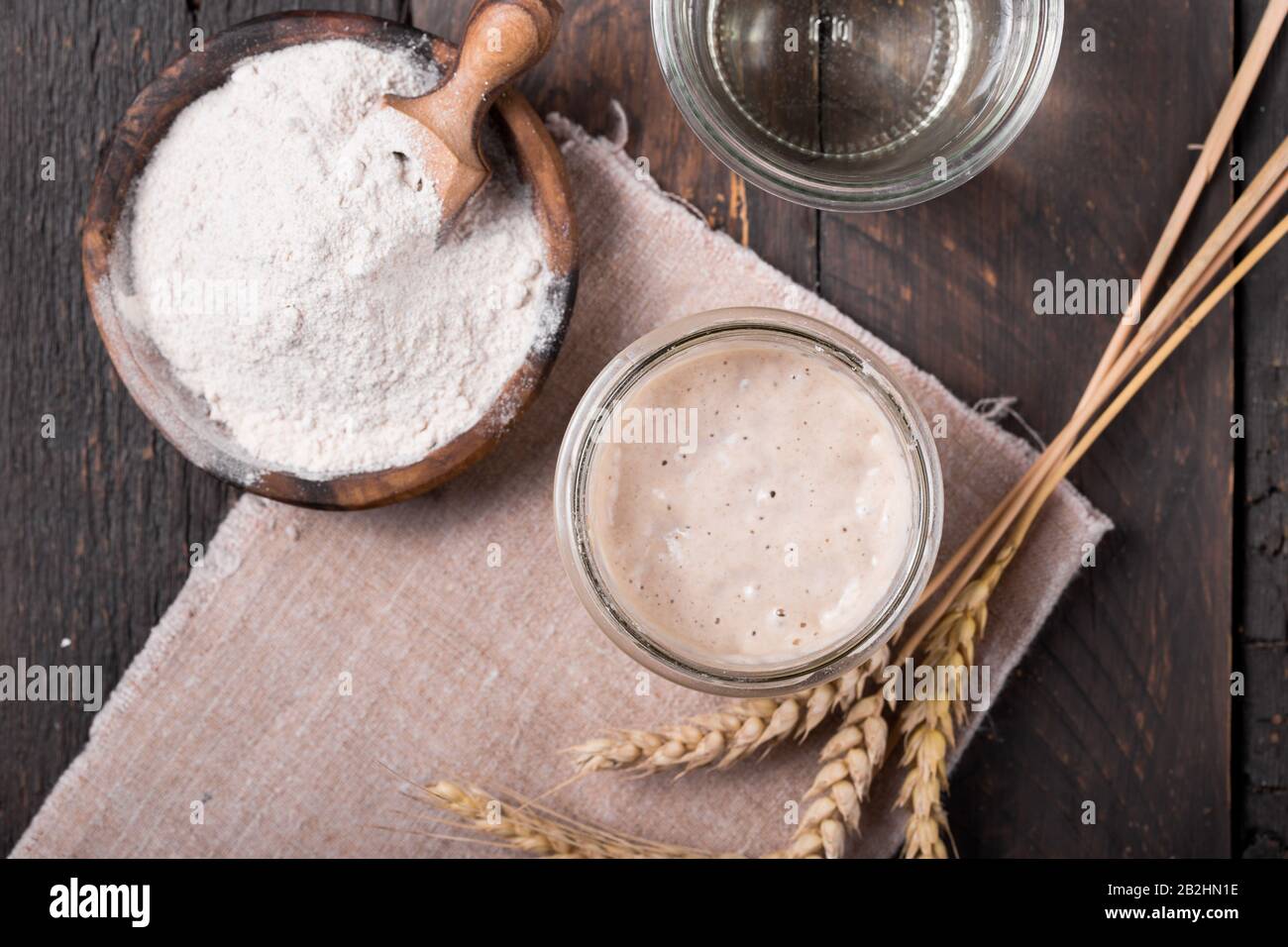 Entrée de levain de pétillant maison, mélange fermenté d'eau et de farine à utiliser comme levain pour la cuisson du pain, sur table en bois Banque D'Images