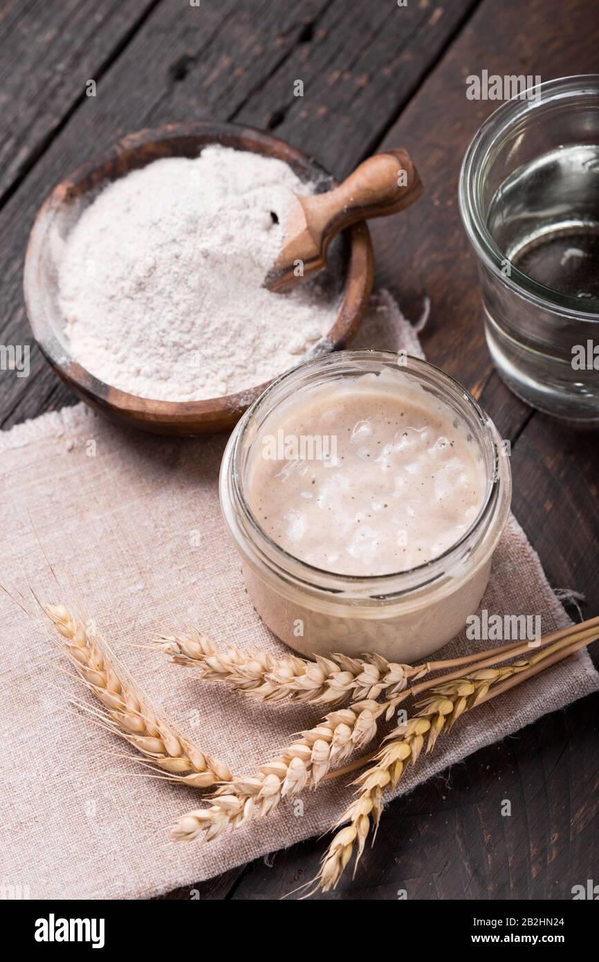 Entrée de levain de pétillant maison, mélange fermenté d'eau et de farine à utiliser comme levain pour la cuisson du pain, sur table en bois Banque D'Images