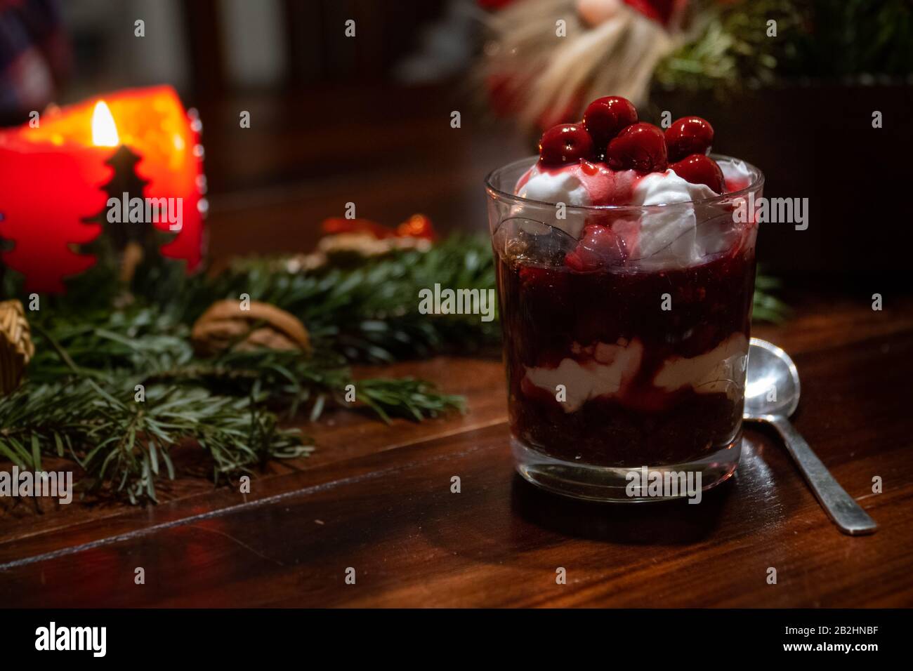 Un dessert végétalien au chocolat, à la crème et aux cerises sur une table décorée de Noël Banque D'Images