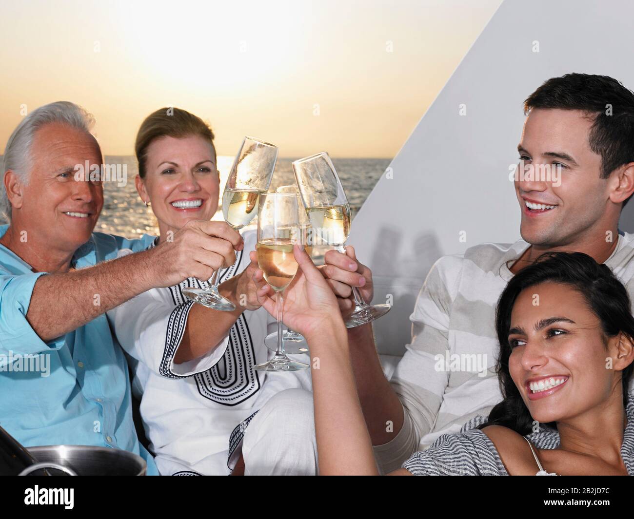 Couple jeune et d'âge moyen se reposant sur un yacht au toaster avec du champagne Banque D'Images