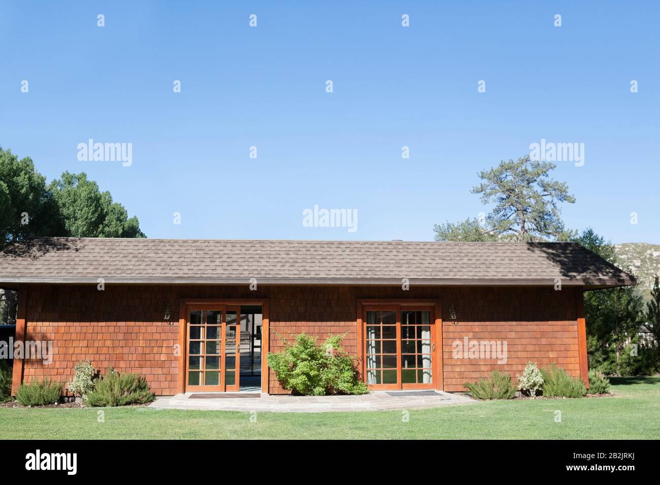 Extérieur d'une maison de campagne et pelouse contre ciel bleu clair Banque D'Images