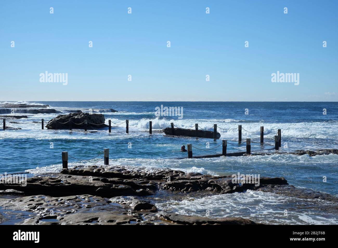 Nagez dans le rectangle bleu de la piscine du rocher Mahon, au bord de l'Australie. Piscine publique de l'époque de la dépression, Sydney, Australie Banque D'Images