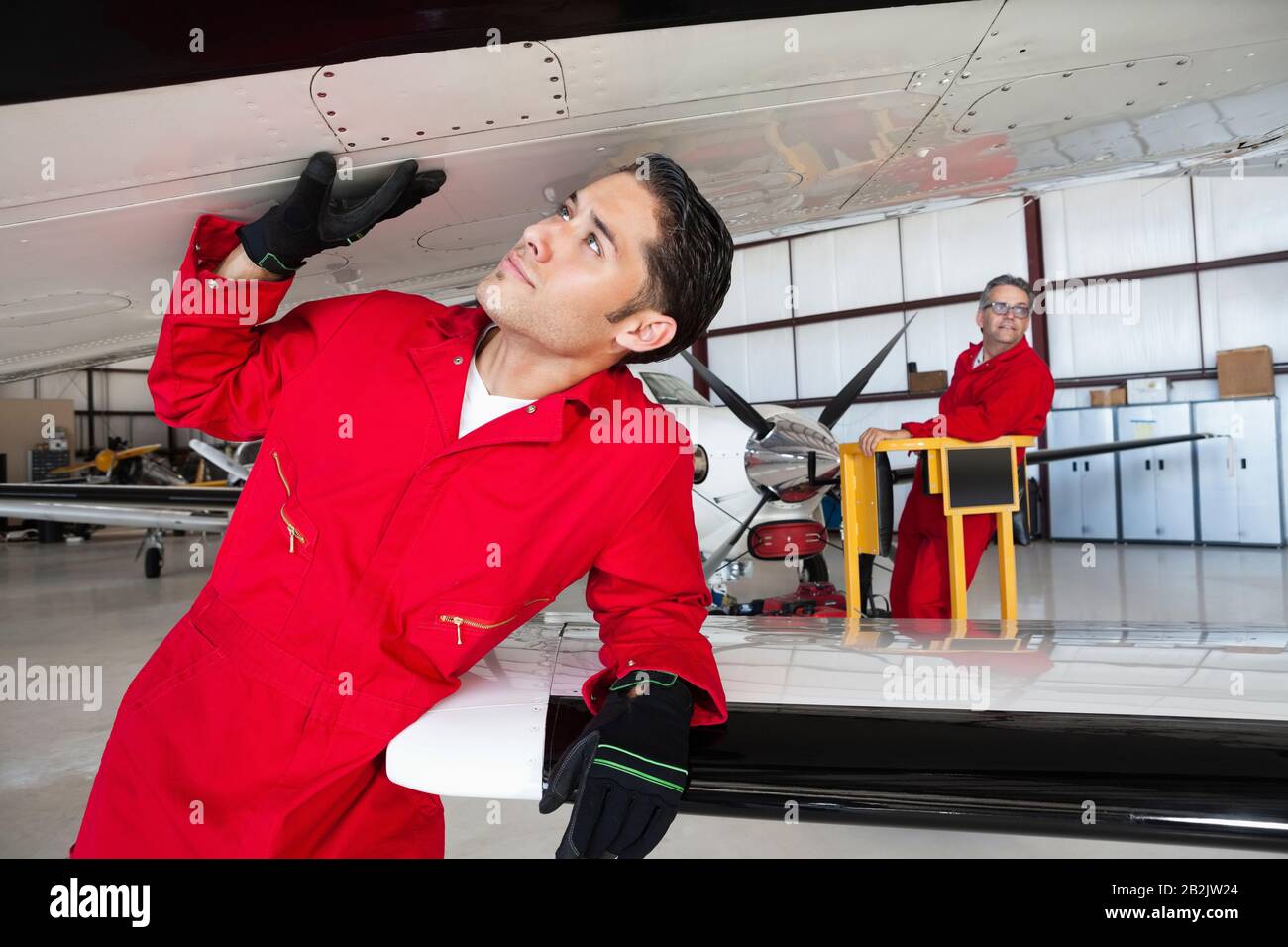 Ingénieurs aéronautiques travaillant dans un hangar d'avion Banque D'Images