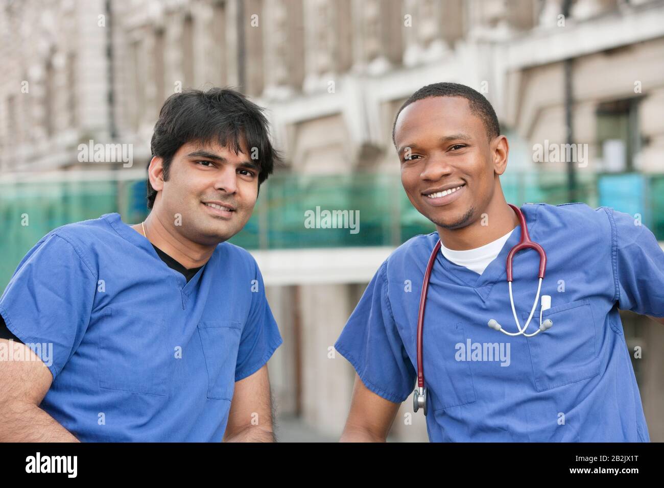 Portrait de médecins multiethniques souriant avec bâtiment en arrière-plan Banque D'Images