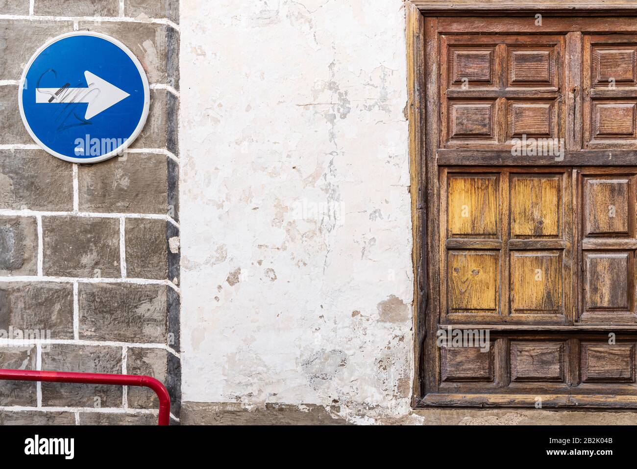 Panneau de signalisation à sens unique sur le vieux mur à côté de la fenêtre avec volets en bois dans la rue la Vera à Guia de Isora, Tenerife, îles Canaries, Espagne Banque D'Images