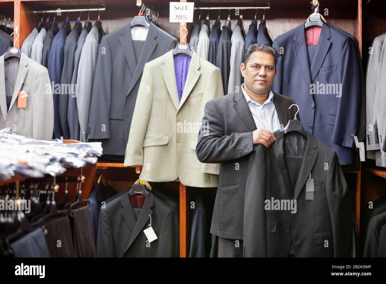 Portrait de l'homme faisant du shopping pour un manteau formel dans un magasin de vêtements pour hommes Banque D'Images