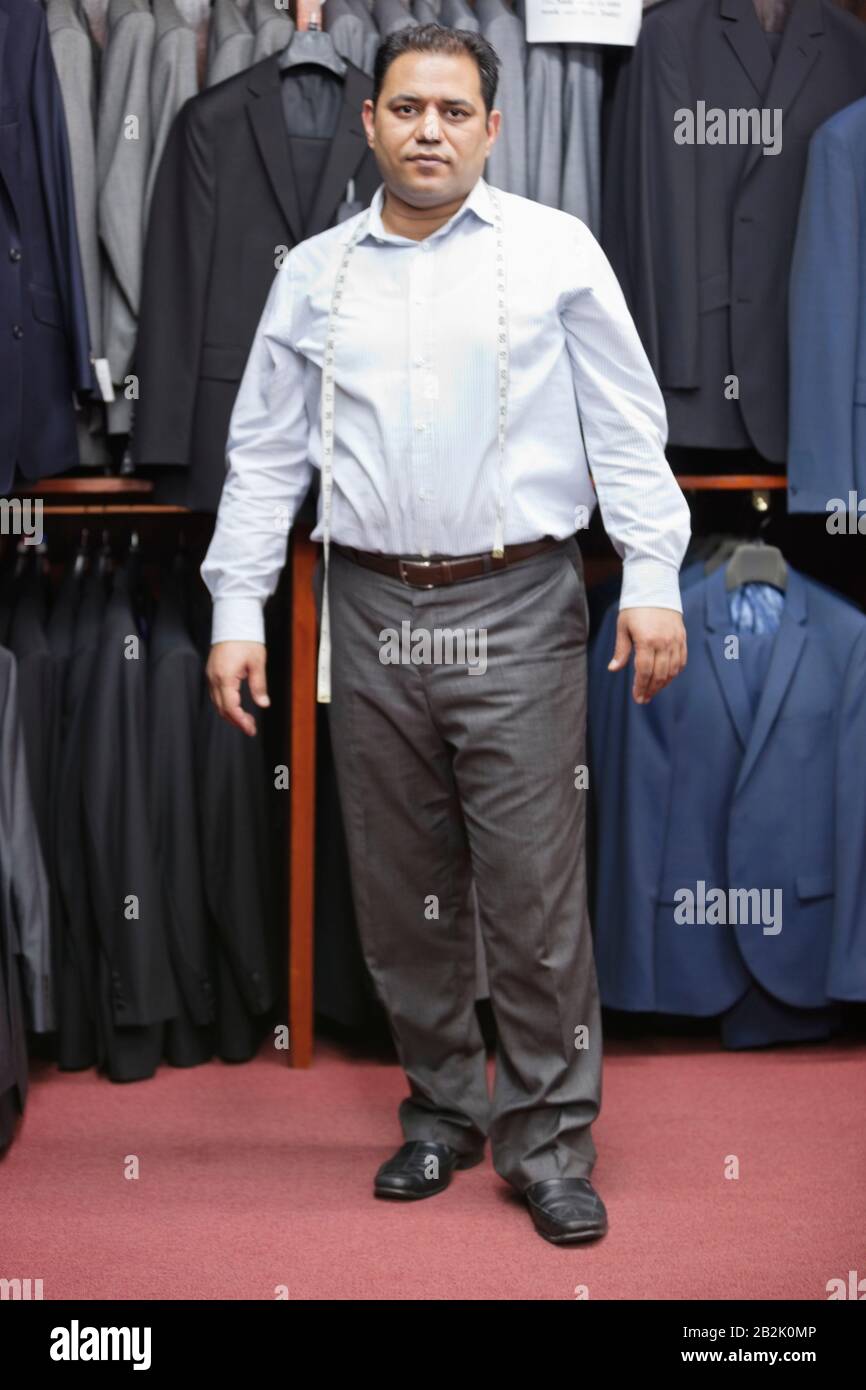 Portrait complet de l'homme sur mesure debout dans le magasin de vêtements pour hommes Banque D'Images