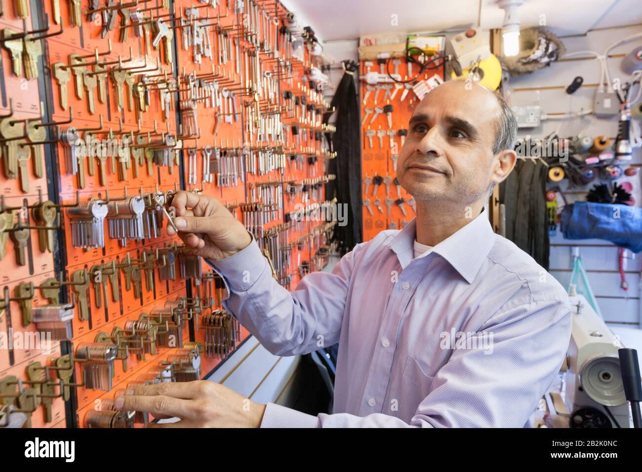 Serrurier mâle senior travaillant dans un magasin de clés Banque D'Images