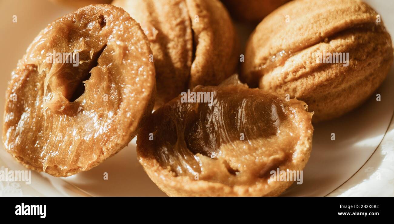 Petits cookies sous forme de noix sur une soucoupe blanche. Banque D'Images
